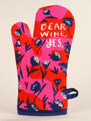 The Blue Q Dear Wine, Yes. Oven Mitt features pink and red colors, blue and white flowers, wine glasses, and the phrase “DEAR WINE, YES.” in white text—a charming romantic gift.