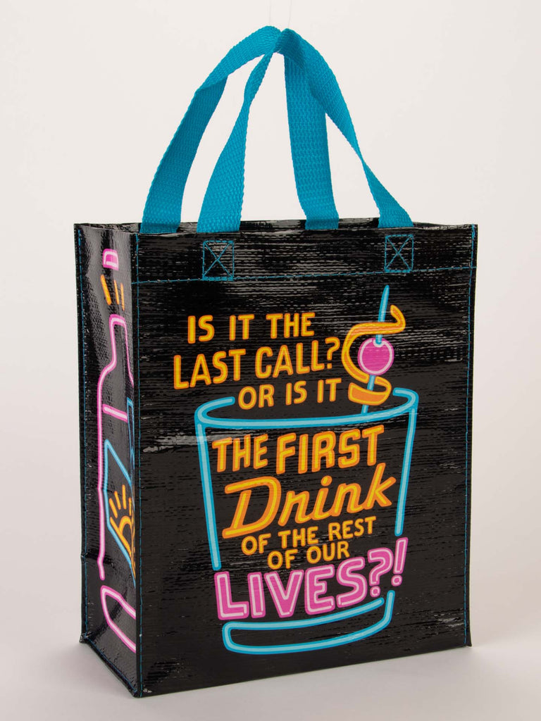The Blue Q Take A Break Sale Pack features a black reusable tote with blue handles, neon "Is it the last call? Or the first drink of the rest of our lives?!" text, cocktail glass and bottle graphics—perfect for gifting!.