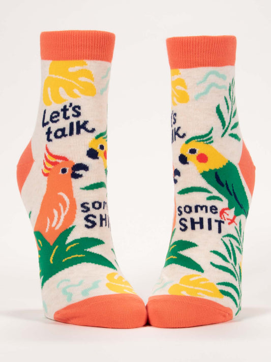Blue Q Let's Talk Some Shit W-Ankle Socks feature colorful combed cotton with orange accents and illustrated parrots, leaves, plus the phrase "Let’s talk some shit" on a cream background.
