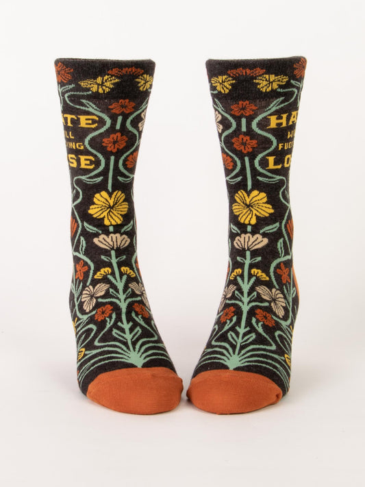 Blue Q's Hate Will Fucking Lose M-Crew Socks feature vibrant floral patterns, orange toes, and a bold phrase on soft combed cotton with a white background.