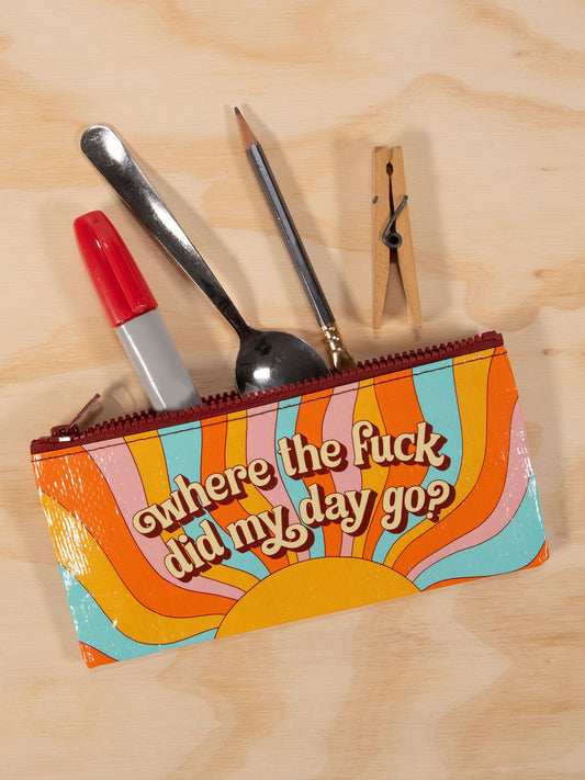 The Blue Q Where'd My Day Go Pencil Case features a retro sunburst design in orange, yellow, and blue, displays the phrase “where the fuck did my day go? (happened again),” and holds items like markers, spoons, pencils, knives, or clothespins.