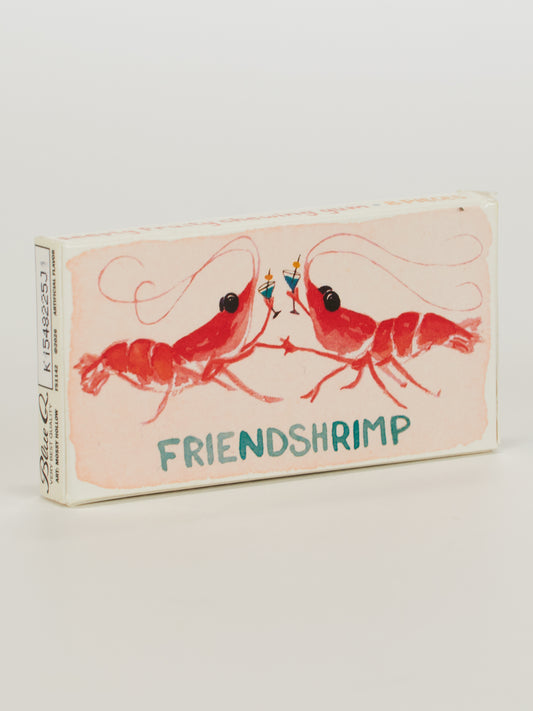 Blue Q’s Friendshrimp Gum: A matchbox featuring two red shrimp holding blue drinks, with "FRIENDSHRIMP" in blue below. Inside are 8 candy-coated fruity gum pieces—perfect for sharing with a friend!.