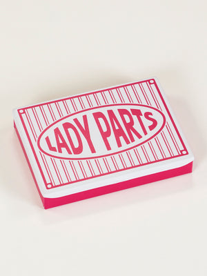 The Lady Parts Pocket Box by Blue Q is a rectangular tin with pink sides and a white lid featuring bold pink "LADY PARTS" text in a striped border—an eye-catching ladies tin box for stylish storage.