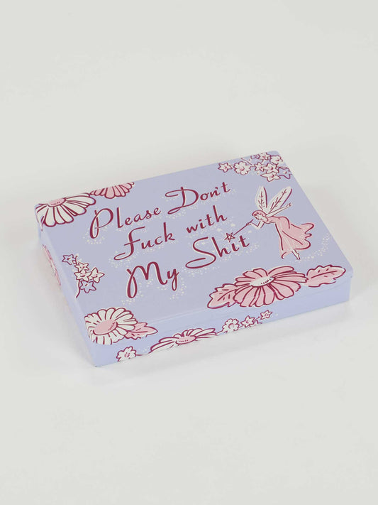 The Please Don't Fuck With My Shit Pocket Box by Blue Q features pink and red florals, a fairy design, and bold script on a lavender lid—ideal as a minimalist wallet or quirky novelty gift.