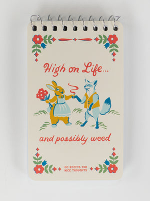 The Blue Q "High On Life...And Possibly Weed" 3x5 spiral notebook features vintage art of a rabbit and fox (the fox holds a joint and lighter), framed by florals. Fun cover text makes it a playful, pocket-sized ideas notebook.