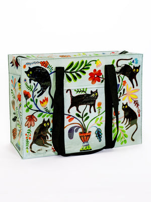 The Blue Q Here Kitty Shoulder Tote features black handles and vibrant illustrations of black cats, green leaves, and flowers around a potted plant—perfect as a stylish cat carrier bag for outings with your feline friend.
