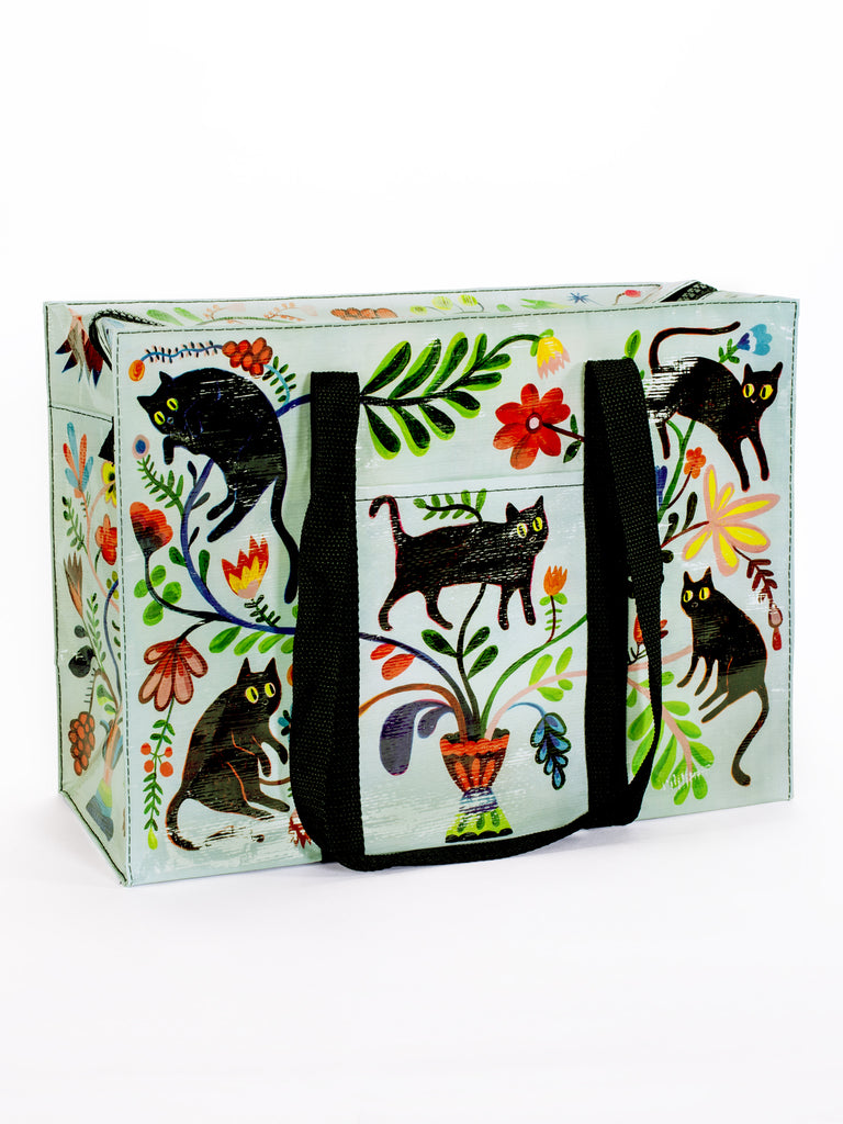 The Blue Q Here Kitty Shoulder Tote features black handles and vibrant illustrations of black cats, green leaves, and flowers around a potted plant—perfect as a stylish cat carrier bag for outings with your feline friend.