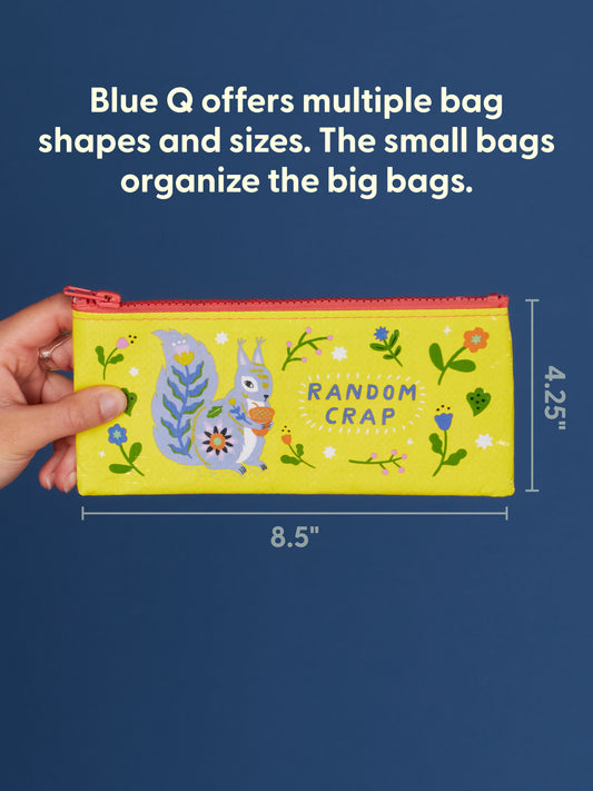 A hand holds Blue Q’s Random Crap Pencil Case, a yellow pouch with a squirrel and flowers, made from recycled material. It measures 8.5" x 4.25". Text above highlights Blue Q’s storage organizer options.