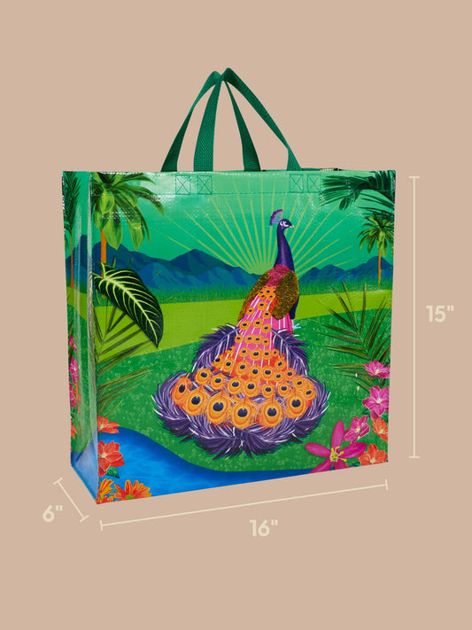 Introducing the Peacock Paradise Shopper by Blue Q—an eco-friendly tote bag adorned with a vivid peacock and floral motif. Made from recycled materials, this reusable shopping bag measures 16 inches wide, 6 inches deep, and 15 inches tall, and is pictured against a neutral background.