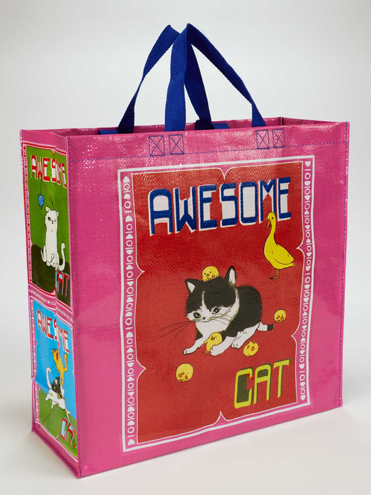 The Awesome Cat Shopper by Blue Q is a colorful tote made from recycled material with blue handles, featuring cartoon cats, yellow chicks, and "AWESOME CAT" text on a bold red and pink background.