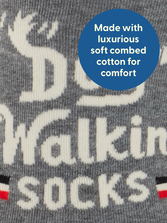 Close-up of grey fabric featuring the Blue Q Dog Walkin’ M-Crew Socks, with a blue circle stating Made with luxurious soft combed cotton for comfort, perfect for walkies.