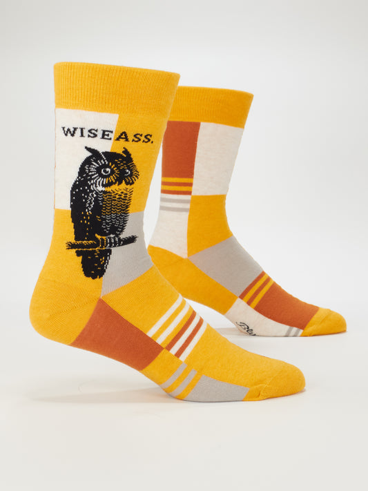 Blue Q Wiseass M-Crew Socks: Combed cotton men’s socks in yellow, orange, tan, and gray with an owl illustration, “WISE ASS.” text on the side, and a witty geometric pattern—perfect for those who love fun style.