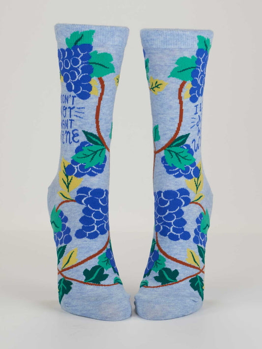 The Blue Q I Don't Not Want Wine W-Crew Socks are light blue, made with soft combed cotton plus nylon and spandex for stretch, and feature a colorful grapevine design with the phrase "I Don’t Not Want Wine" displayed upright.