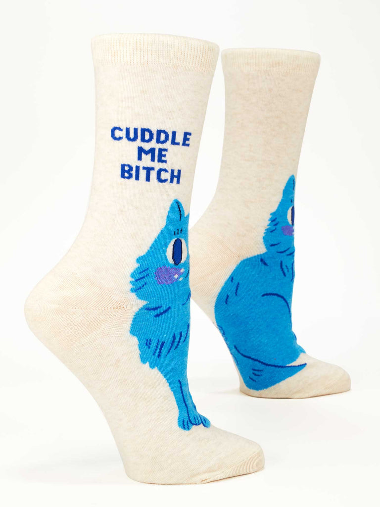 Blue Q's Cuddle Me Bitch Crew Socks are cream-colored women's cotton socks featuring a blue cartoon cat and "CUDDLE ME BITCH" in bold blue letters near the top.