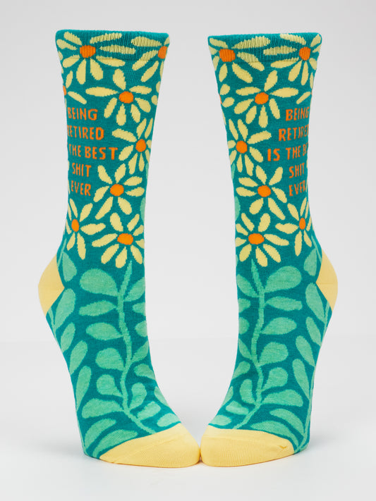Blue Q’s “Being Retired Is The Best Shit Ever” W-Crew Socks are turquoise women’s socks featuring yellow toes and heels, adorned with floral and leaf designs. Made from soft combed cotton, these socks fit women’s shoe sizes 5–10. The text on the socks reads: Being retired is the best shit ever.