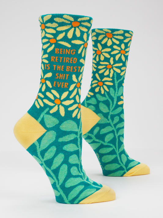 Blue Q’s Being Retired Is The Best Shit Ever W-Crew Socks feature two teal, combed cotton socks with yellow toes and heels, decorated with large yellow flowers and green leaves. Designed to fit women’s shoe sizes 5–10, these socks are completed with the playful text: Being retired is the best shit ever.