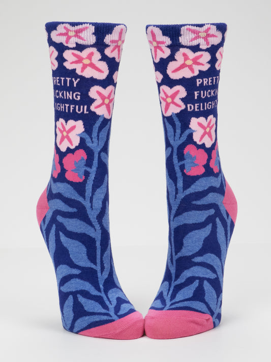 Introducing the Pretty Fucking Delightful W-Crew Socks by Blue Q: women’s shoe socks (size 5-10) crafted from soft combed cotton. These cozy blue socks feature pink toes and heels, adorned with pink flowers and blue leaves, and display the phrase “PRETTY FUCKING DELIGHTFUL” in bold white lettering at the top.