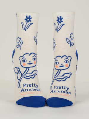 Blue Q’s Pretty Anxious Ankle Socks for women fit shoe size 5-10, are made from soft combed cotton, and feature blue toes and heels, a smiling blue flower with rosy cheeks, "Pretty Anxious" on the sole, and scattered blue flowers.