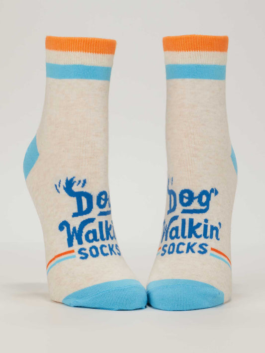 Blue Q Dog Walkin' Ankle Socks: Cream women's socks with blue toes and heels, orange/blue stripes at the top, “Dog Walkin’ Socks” in blue on the front, plus a small blue dog paw in the design.