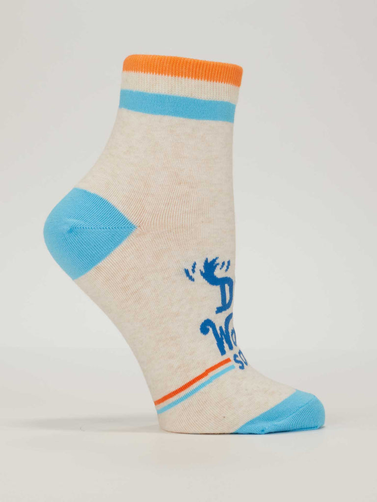 The Blue Q Dog Walkin' Ankle Socks are beige with blue toe and heel, orange and blue stripes at the cuff, and feature blue text with a moose illustration. These comfy women's socks show a partial phrase reading "Dri World Sox.