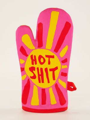 The Blue Q Hot Shit Oven Mitt features bold red lettering and a vibrant ray design—perfect for anyone who loves spicy food or can handle hot sauce like a pro.
