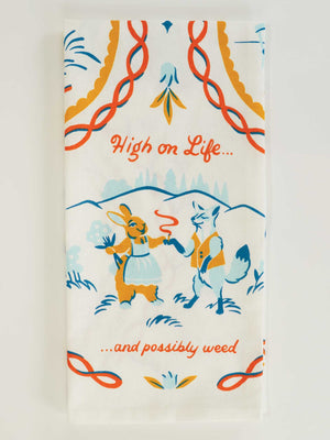 The Blue Q "High On Life...And Possibly Weed" Dish Towel features an illustrated rabbit and fox standing, holding a joint, with playful text and blue, orange, and yellow tones—a fun decorative piece for your kitchen.