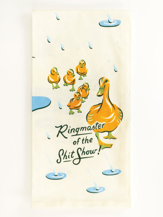 The Blue Q Ringmaster Of The Shitshow Dish Towel features a mother duck with six ducklings in puddles, made from unbleached cotton and playfully printed with "Ringmaster of the Shit Show!.