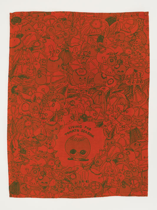 The Blue Q Living For Tomato Season Dish Towel is a red unbleached cotton towel with a bold “LIVING FOR TOMATO SEASON” message and whimsical black line art of fruits and veggies, centered around a tomato.