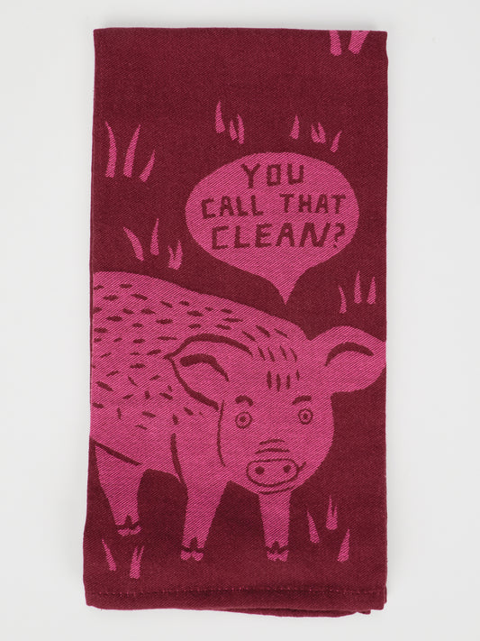 The “You Call That Clean? Dish Towel” by Blue Q is a maroon, super-absorbent kitchen towel crafted from unbleached cotton. It features a playful pink pig illustration with a speech bubble that reads, “You call that clean?” surrounded by whimsical grass details, making it both practical and charming.
